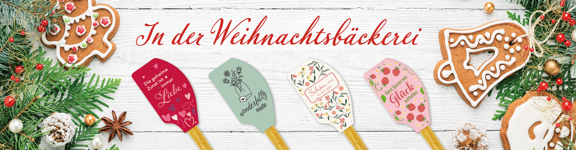 Ein festlicher Weihnachts-Hintergrund mit grünen Zweigen, Weihnachtskeksen und fünf dekorativen Teigschabern. Text: "In der Weihnachtsbäckerei".