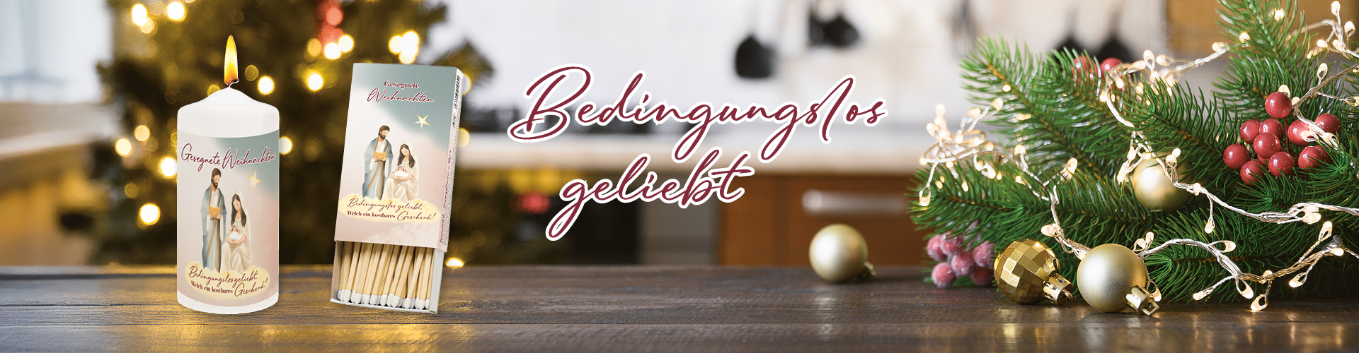 Kerze und eine Zündholzbox mit Weihnachtsmotiv auf einem Holztisch, umgeben von Weihnachtsdeko. Text: Bedingungslos geliebt