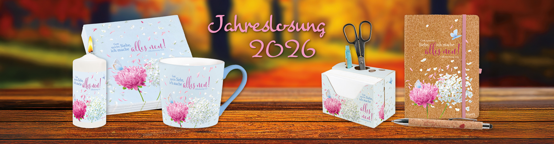 Tischdeko und Schreibwaren, dekoriert mit grafischem Hortensien Motiv der Jahreslosung 2026, vor herbstlichem Hintergrund.