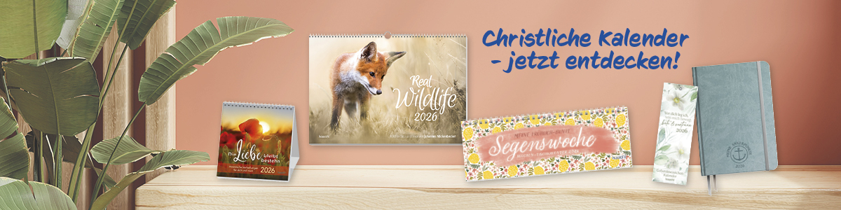 Verschiedene christliche Kalender für 2026, präsentiert auf einem Tisch mit Pflanzen im Hintergrund.