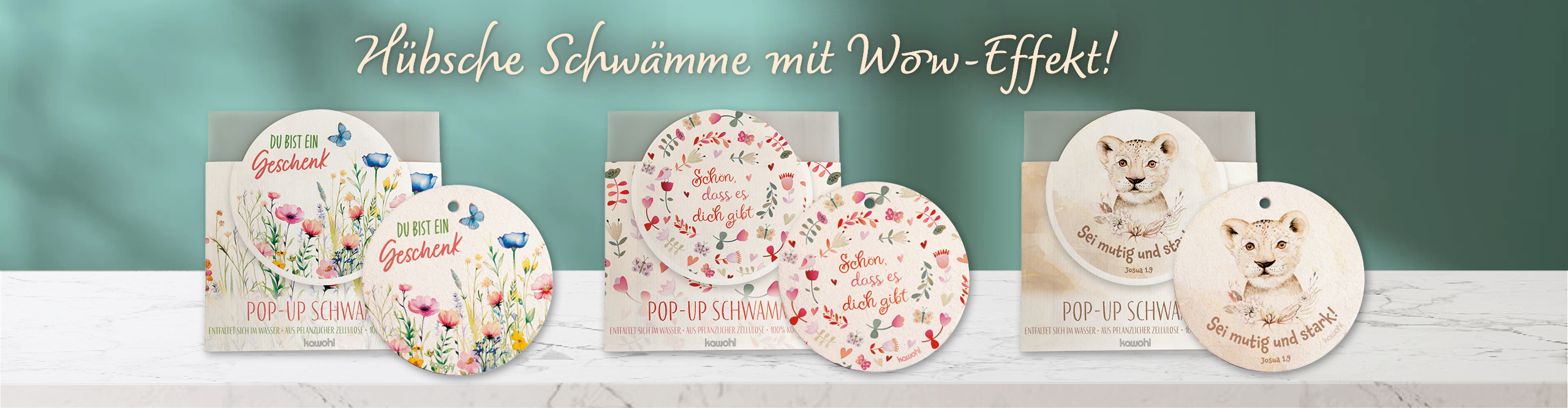 Bunte Pop-up-Schwämme mit inspirierenden Sprüchen und hübschen Motiven auf einem hellen Holztisch. Text: Hübsche Schwämme mit Wow-Effekt!