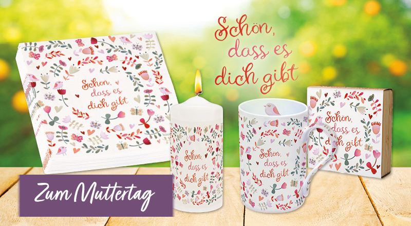 Banner mit Tisch vor grüner Wiese, auf dem Tisch stehen Servietten, eine Kerze, eine Tasse und ein Bambus-Teelichthalter, auf allen ist das gleiche, filigrane Blütenmuster und der Text „Schön, dass es dich gibt“. Auf dem Banner steht „Zum Muttertag“.