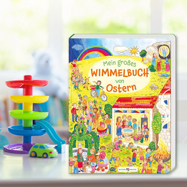 Buchcover von 'Mein großes Wimmelbuch von Ostern' auf einem Tisch mit Spielzeug vor verschwommenem Kinderzimmer.