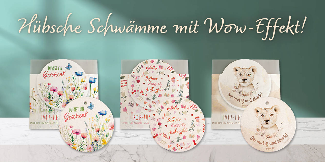 Bunte Pop-up-Schwämme mit inspirierenden Sprüchen und hübschen Motiven auf einem hellen Holztisch. Text: Hübsche Schwämme mit Wow-Effekt!