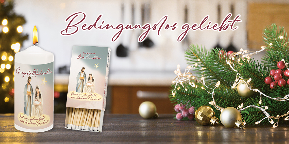 Kerze und eine Zündholzbox mit Weihnachtsmotiv auf einem Holztisch, umgeben von Weihnachtsdeko. Text: Bedingungslos geliebt