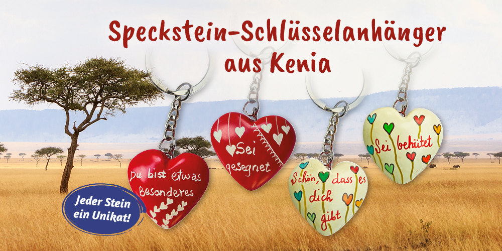 Speckstein-Schlüsselanhänger aus Kenia in Herzform mit Gravuren, darunter rote Herzen mit deutschen Sprüchen und zwei cremefarbende Herzen mit bunten Blumen vor Savannen-Hintergrund. Text: Jeder Stein ein Unikat!