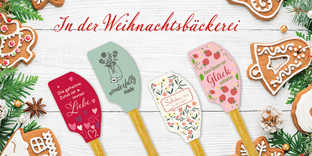 Ein festlicher Weihnachts-Hintergrund mit grünen Zweigen, Weihnachtskeksen und fünf dekorativen Teigschabern. Text: "In der Weihnachtsbäckerei".