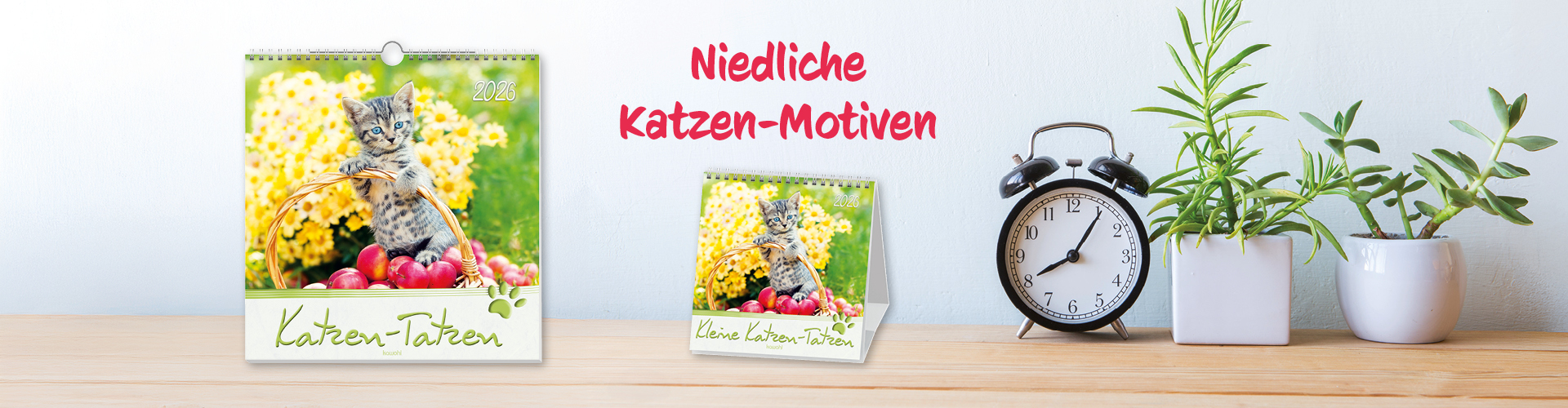 Banner mit Kalendern mit niedlichen Katzenmotiven, einer Uhr und Pflanzen auf einem Holzregal.
