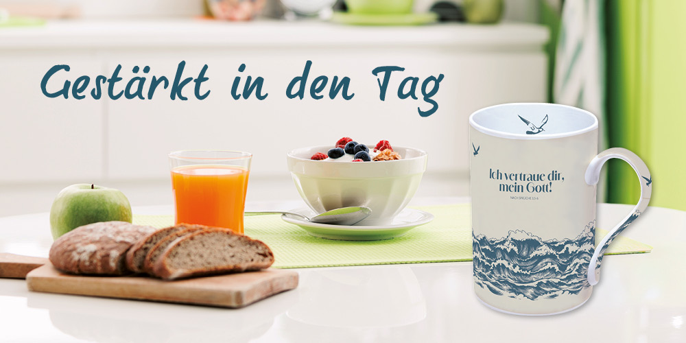 Frühstückstisch mit einer Tasse, einer Müslischale, einem Glas Saft, Brot und einem grünen Apfel. Text: Gestärkt in den Tag.