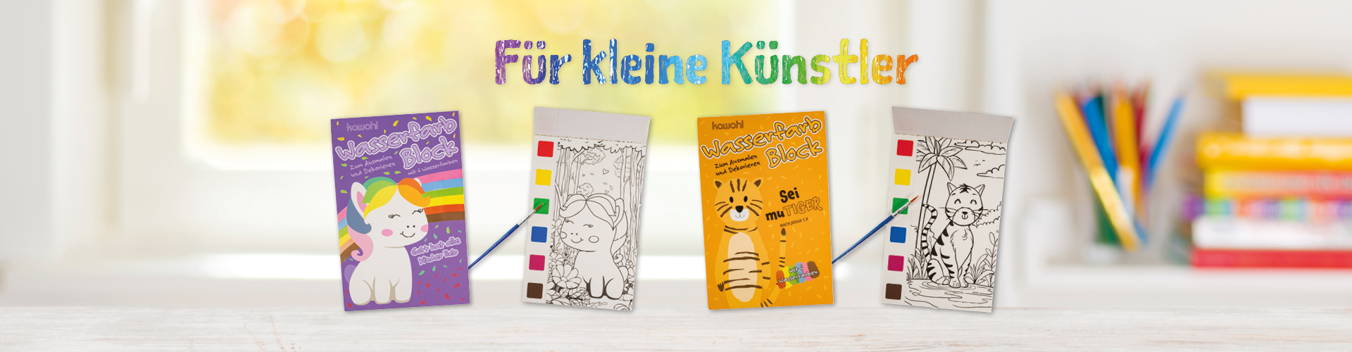 Heller Holztisch vor unscharfem Fensterhintergrund. Auf dem Tisch kann man zwei kleine Wasserfarbblöcke erkennen mit Pony- und Tigermotiv und je ein Innenbild mit dazugehöriger Farbpalette und Pinsel.