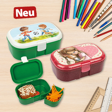 Bunte Brotdosen in zwei Designs: eine mit Kindern beim Fußball spielen und eine mit einem Mädchen. Zahlreiche Stifte im Hintergrund.